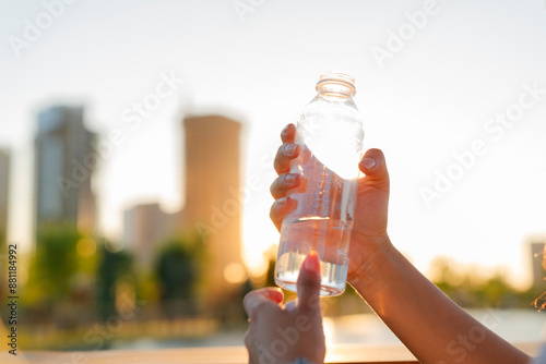 Hand holding a bottle of water in nature