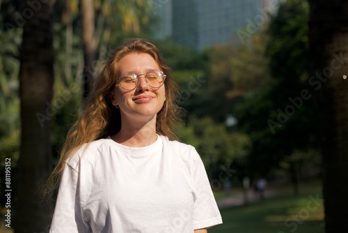 portrait of a young beautiful woman in the park enjoying the warm weather in spring or summer