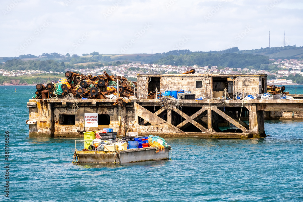 Old and discarded booms, fishing nets, chains, taackle and fishing equipment on a disused jetty in Brixham Harbour Old and discarded booms, fishing nets, chains, taackle and fishing equipment on a disused jetty in Brixham Harbour