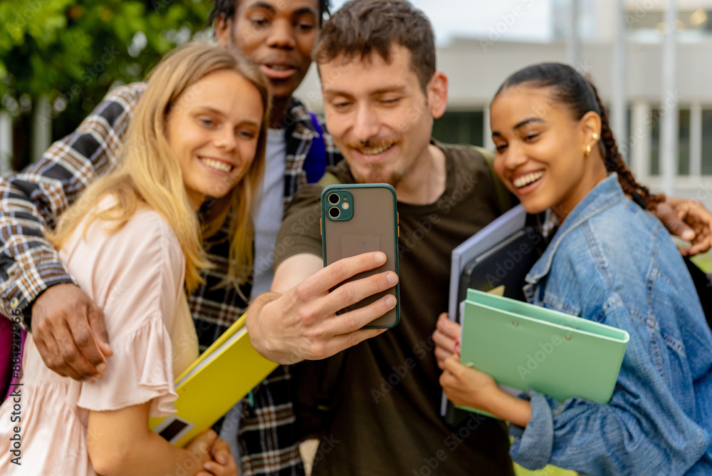 Obraz premium multiracial group of young college or high school students taking a selfie picture with a smartphone after class.