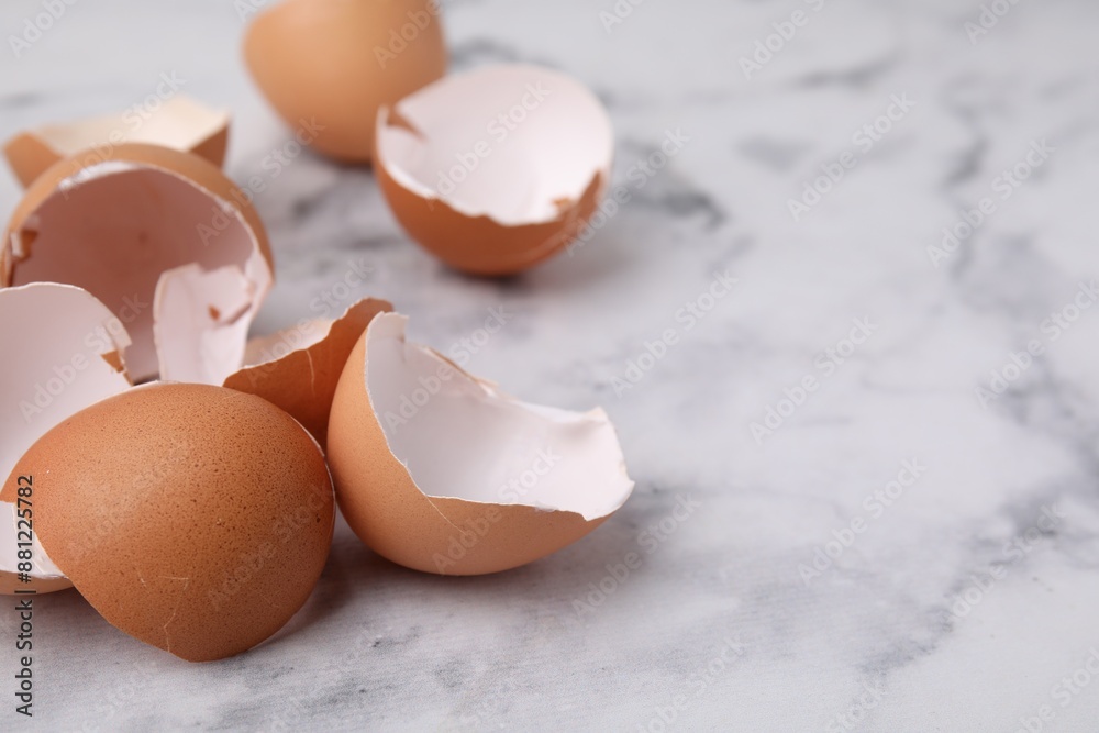 Broken eggshells on light marble table, closeup. Space for text Broken eggshells on light marble table, closeup. Space for text