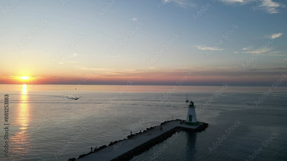 Sunset pier aerial circling Port Dalhousie Range Front Lighthouse on Lake Ontario, near Lakeside Park and the harbour in St. Catharines, Ontario, Canada in summer of July, 2024.
