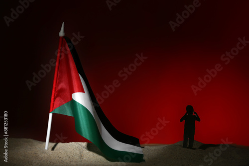 Child silhouette with flag of Palestine on sand against red background. Sorrow concept