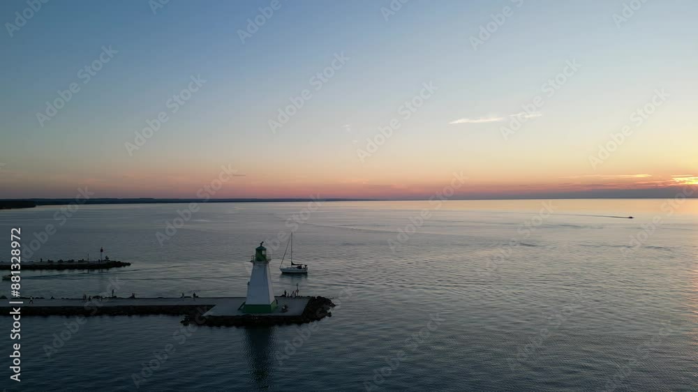 Sunset pier aerial circling Port Dalhousie Range Front Lighthouse on Lake Ontario, near Lakeside Park and the harbour in St. Catharines, Ontario, Canada in summer of July, 2024. Sunset pier aerial circling Port Dalhousie Range Front Lighthouse on Lake Ontario, near Lakeside Park and the harbour in St. Catharines, Ontario, Canada in summer of July, 2024.
