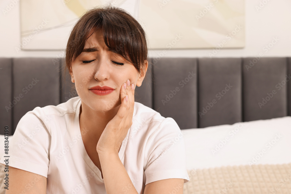 Upset young woman suffering from toothache indoors, space for text Upset young woman suffering from toothache indoors, space for text