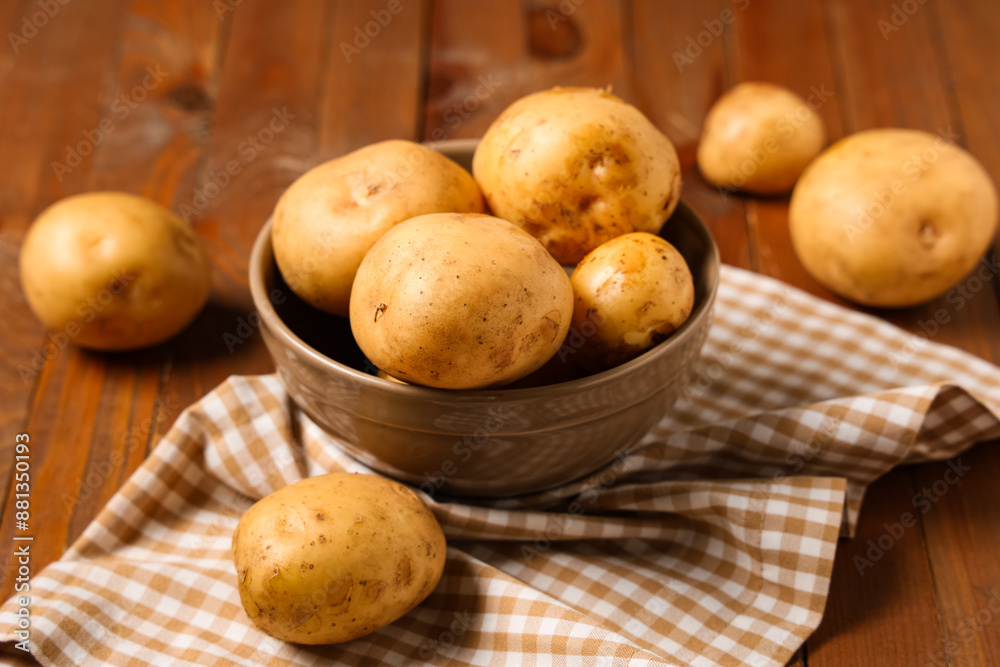 Bowl with raw potatoes on wooden background Bowl with raw potatoes on wooden background