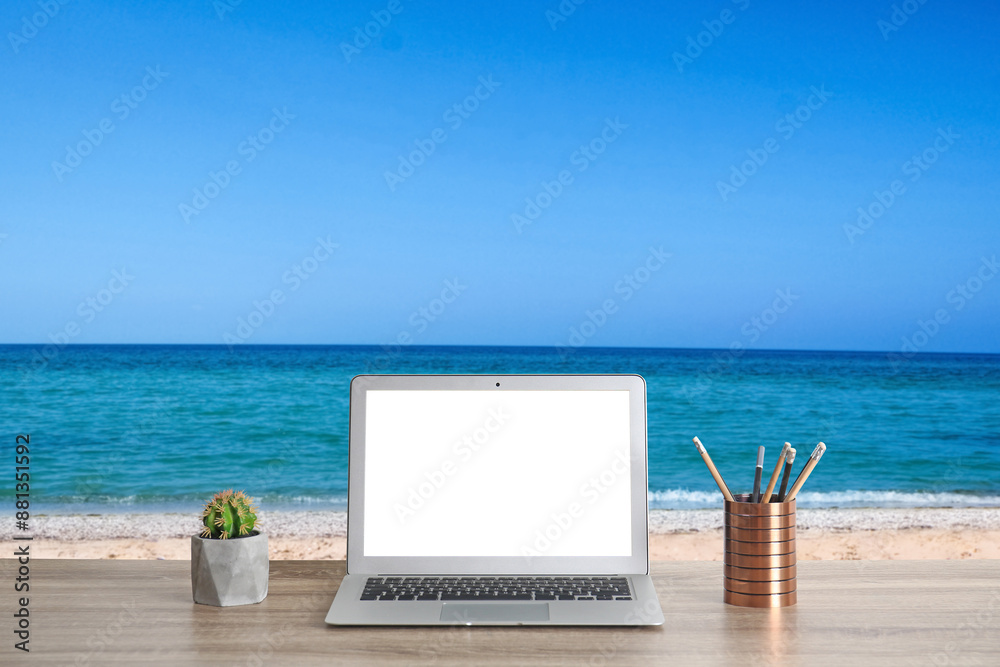 Workplace at beach, distant office. Table with laptop on sandy seashore. Mockup for design Workplace at beach, distant office. Table with laptop on sandy seashore. Mockup for design