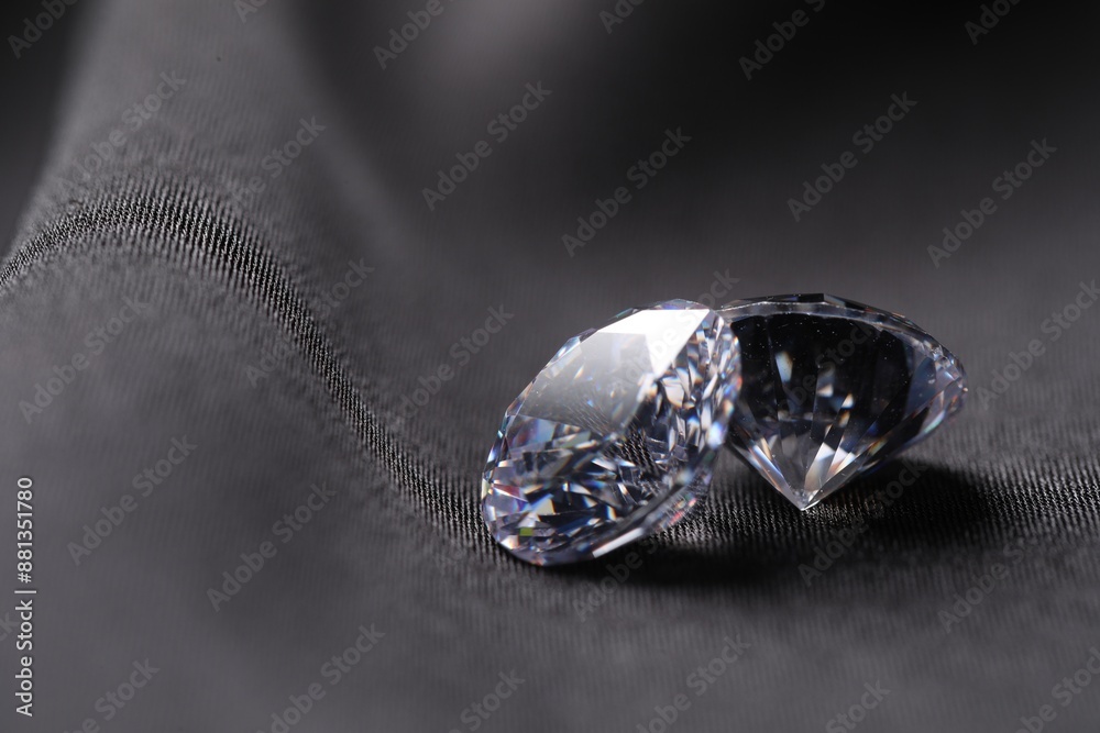 Two beautiful shiny diamonds on black fabric, closeup. Space for text Two beautiful shiny diamonds on black fabric, closeup. Space for text
