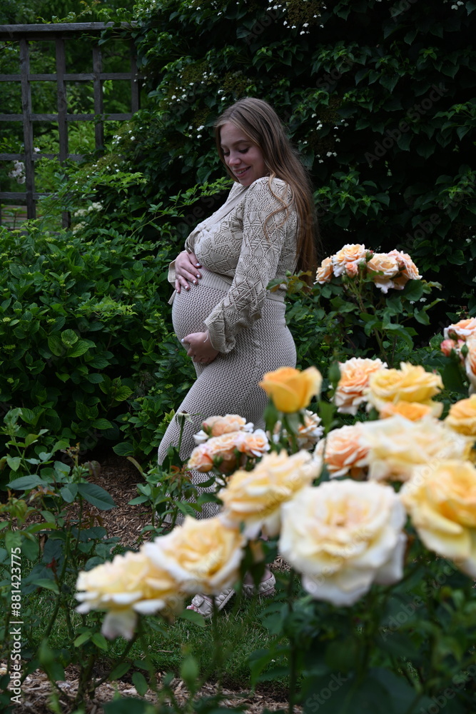 pregnant woman in the park with roses pregnant woman in the park with roses