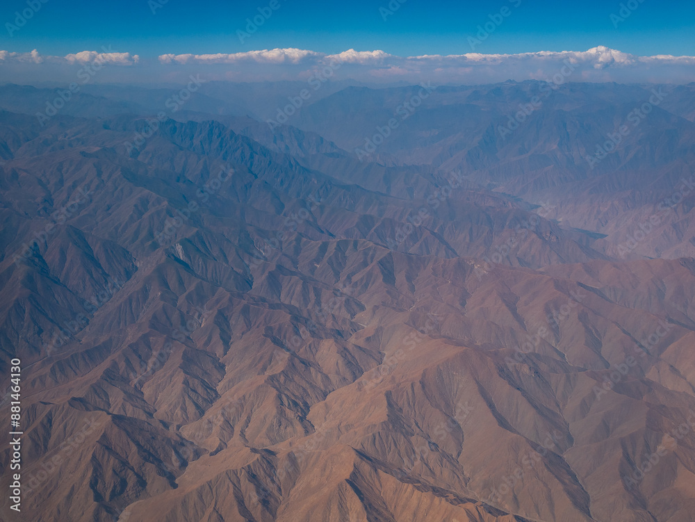 View From the Airplane of the Rocky Mountains Over Peru with a Blue Sky as a Background