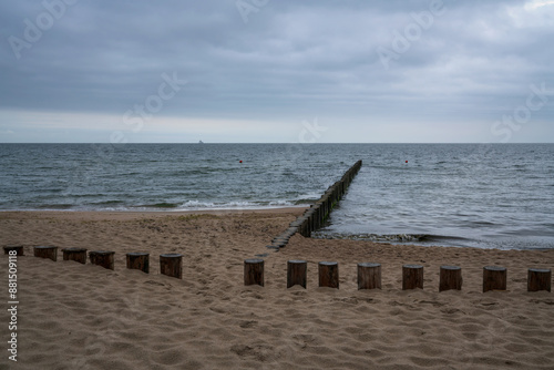 Fototapeta Naklejka Na Ścianę i Meble -  View of the Baltic Sea and wooden breakwaters of the city beach on a cloudy summer day, Svetlogorsk, Kaliningrad region, Russia