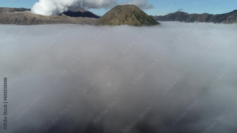Aerial View of Mount Bromo in the Middle of a Sea of Sand Bromo Tengger Semeru National Park and clouds. Aerial View of Mount Bromo in the Middle of a Sea of Sand Bromo Tengger Semeru National Park and clouds.