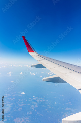 View from the airplane window at a beautiful cloudy sky and the airplane wing