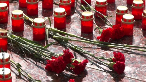 Carnations on a marble slab close-up and funeral lamps. Laying flowers. Day of remembrance and mourning. photo