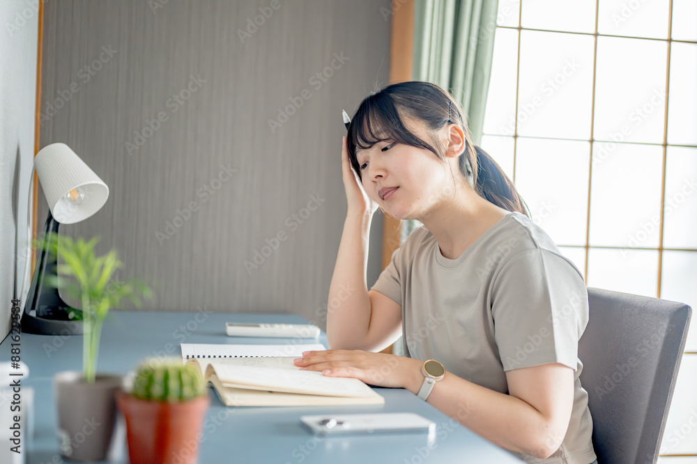 勉強机で悩む私服女性 勉強机で悩む私服女性