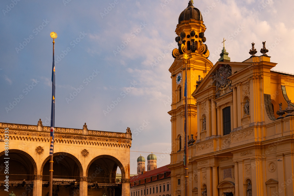 Fototapeta premium View from Odeonsplatz of the Feldherrnhalle and Theatinerkirche in the golden evening light. Munich, Bavaria, Germany. In the background the two towers of the Frauenkirche