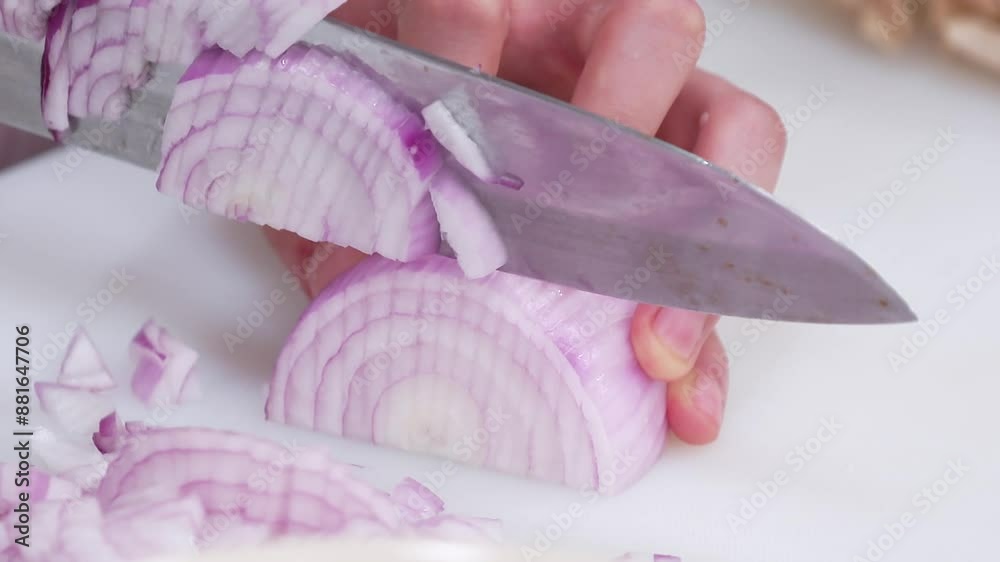 주방에서 흰 도마 위에 적양파를 써는 장면 주방에서 흰 도마 위에 적양파를 써는 장면