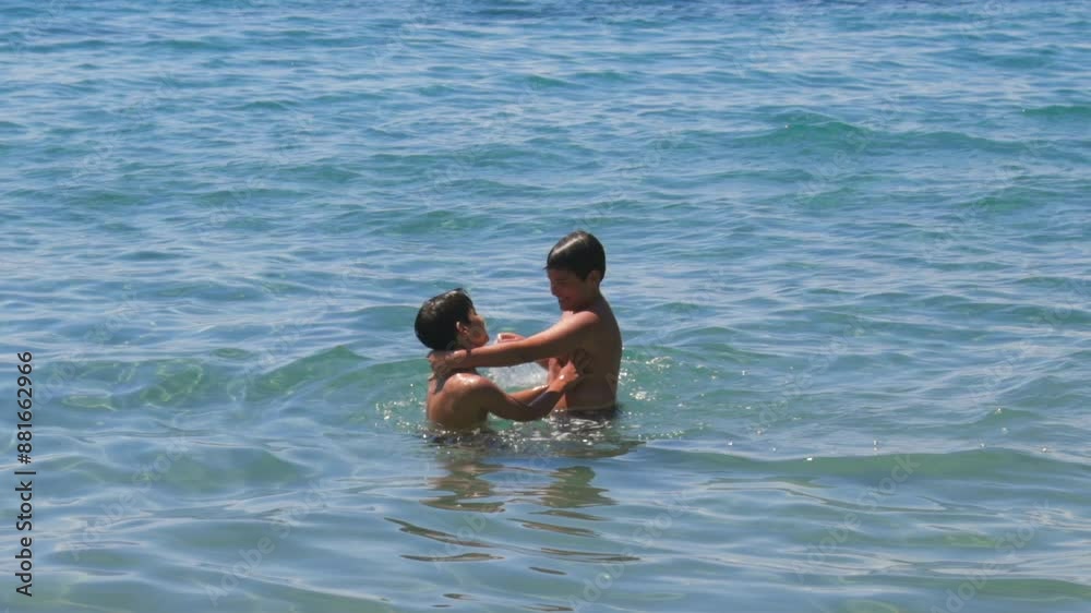 Caucasian brothers share a hug and splashing each other in the sea, medium 100fps, slow motion footage Caucasian brothers share a hug and splashing each other in the sea, medium 100fps, slow motion footage