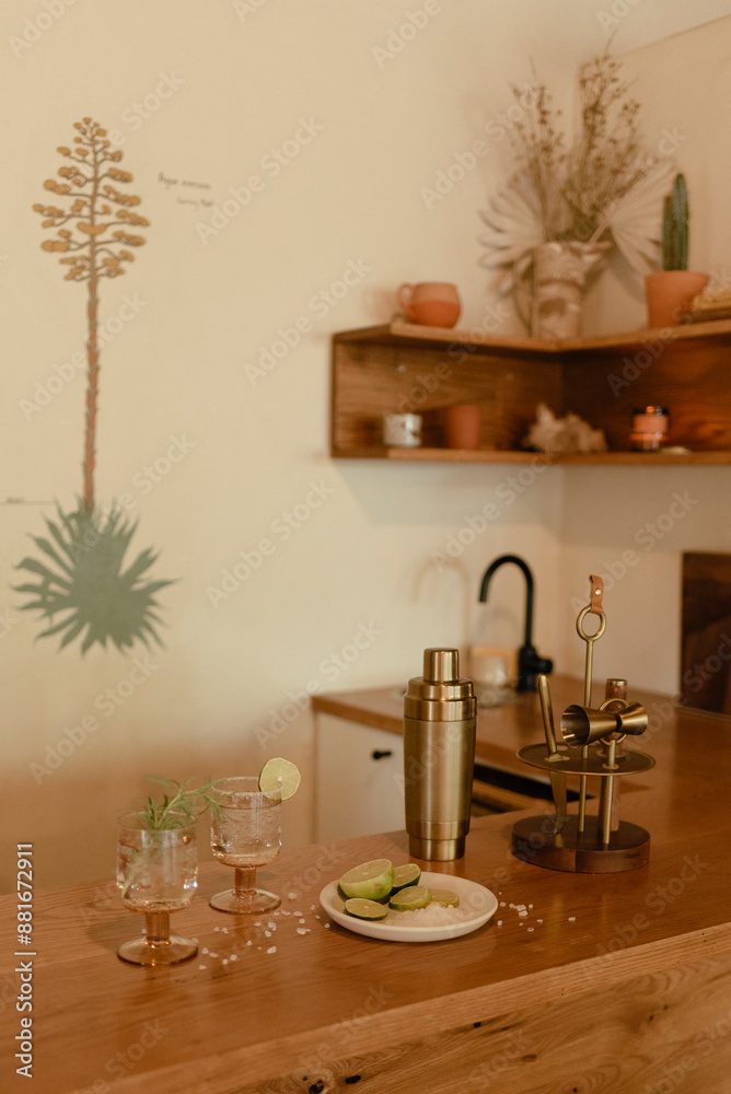 Home bar with cocktails and lime slices on a wooden counter. Home bar with cocktails and lime slices on a wooden counter.