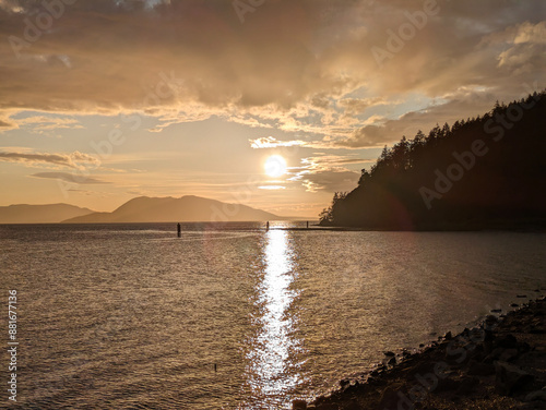 Dramatic golden sunset over the ocean with clouds and mountains - Chuckanut Washington