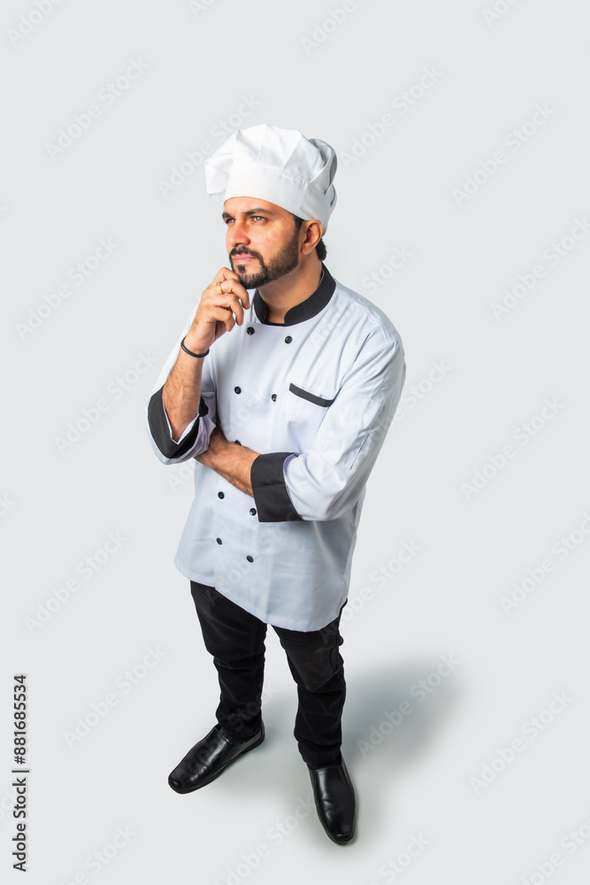 Young Indian Asian chef with skeptical look, high view isolated against white background