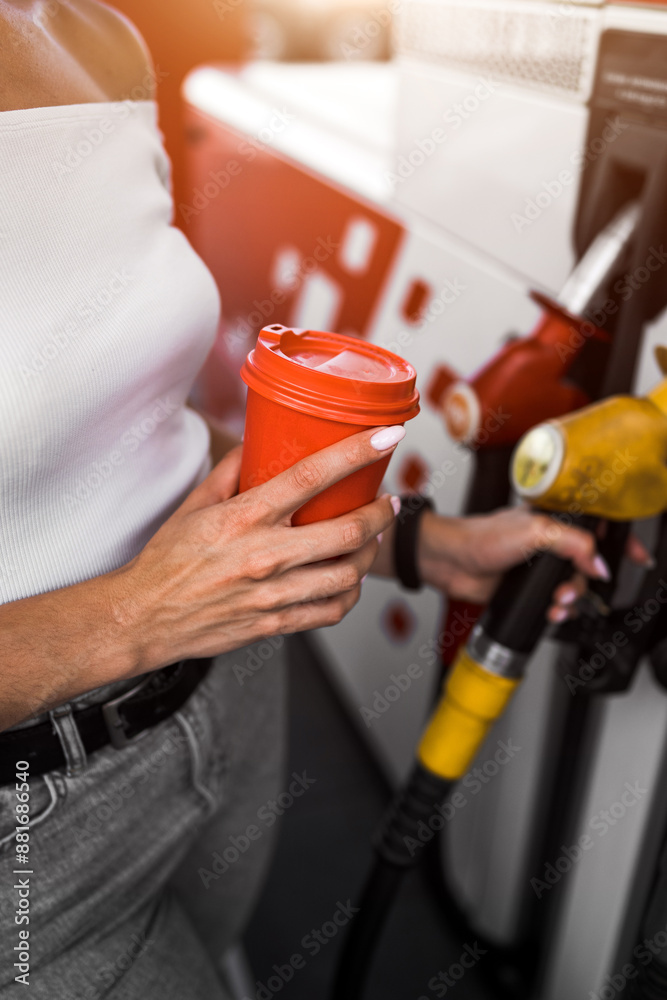 A woman fills a car with fuel at a gas station. Gas station service. Refueling concept. A woman fills a car with fuel at a gas station. Gas station service. Refueling concept.