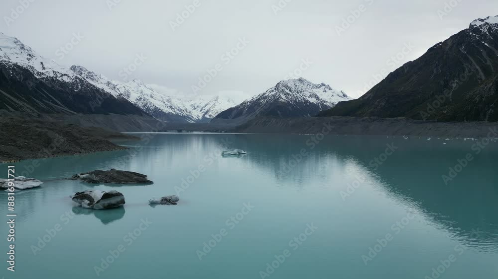 Drone flies above Tasman Glacier lake, capturing the snowy peaks of Mount Cook National Park. Drone flies above Tasman Glacier lake, capturing the snowy peaks of Mount Cook National Park.