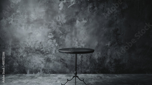 A stock image of a metal round table positioned against a charcoal grey wall. The setup is clean and centered, with a simple composition that offers plenty of space for product displays. 