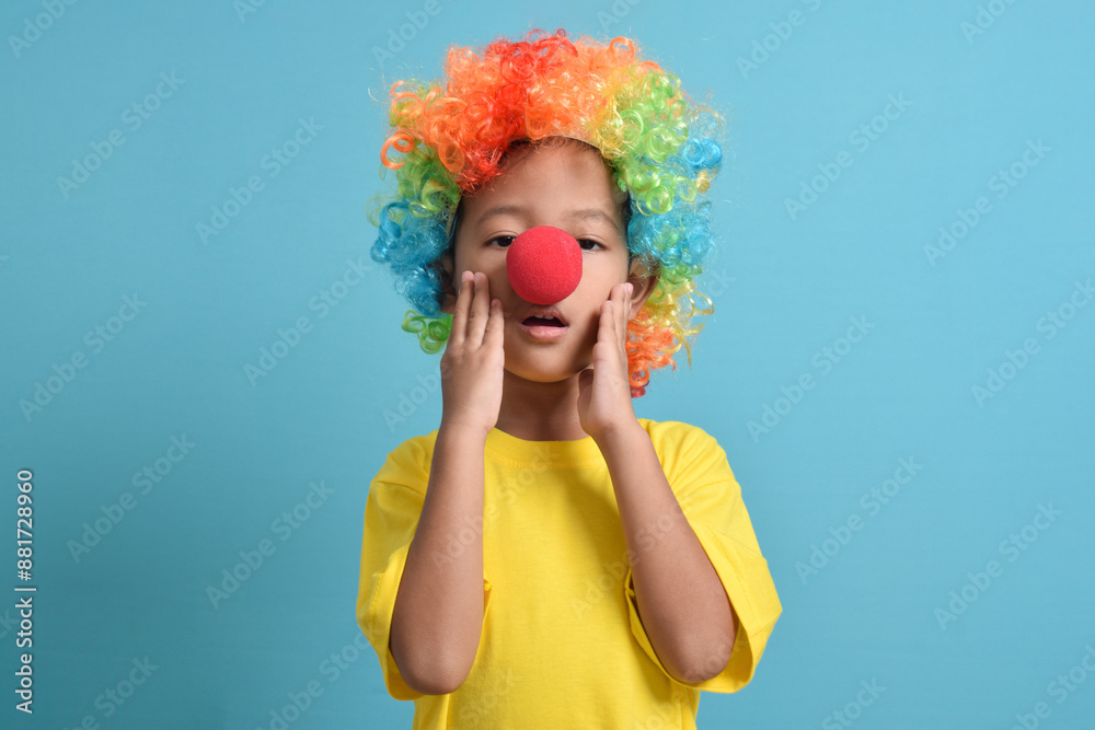 © Mulad Images - Cute little asian boy with clown wig and clown nose, surprised pose isolated on blue background. copy space © Mulad Images - Cute little asian boy with clown wig and clown nose, surprised pose isolated on blue background. copy space
