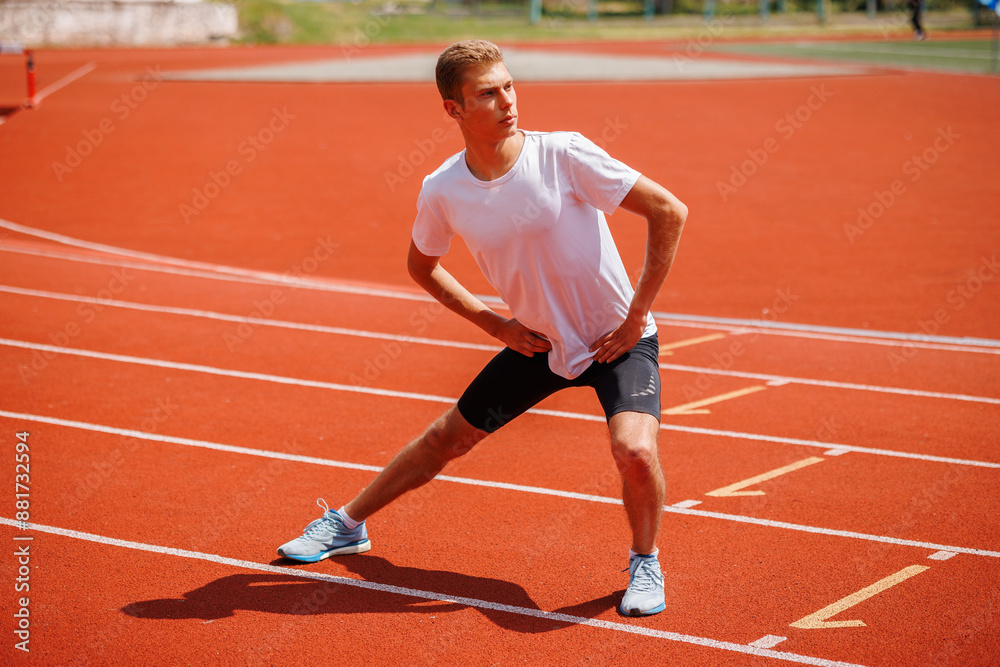 Male athlete stretching on running track Male athlete stretching on running track