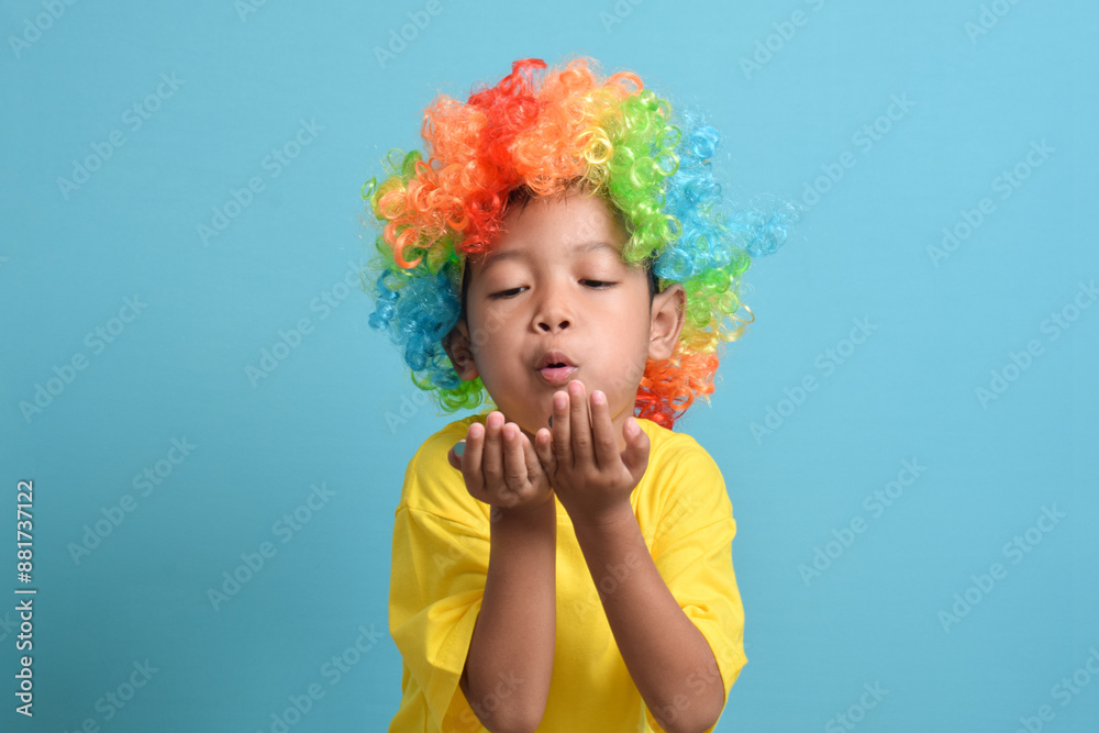 Cute little asian boy in clown wig isolated on blue background. copy space Cute little asian boy in clown wig isolated on blue background. copy space