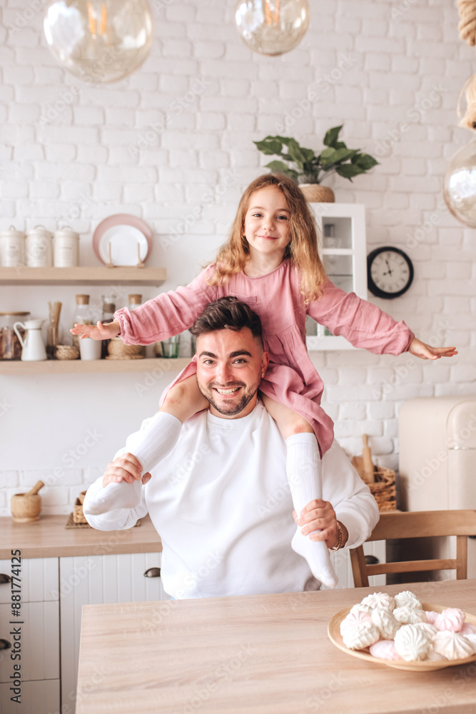 A young man and his daughter spend time together at home on Father's Day. Concept of happy family and spending time together A young man and his daughter spend time together at home on Father's Day. Concept of happy family and spending time together