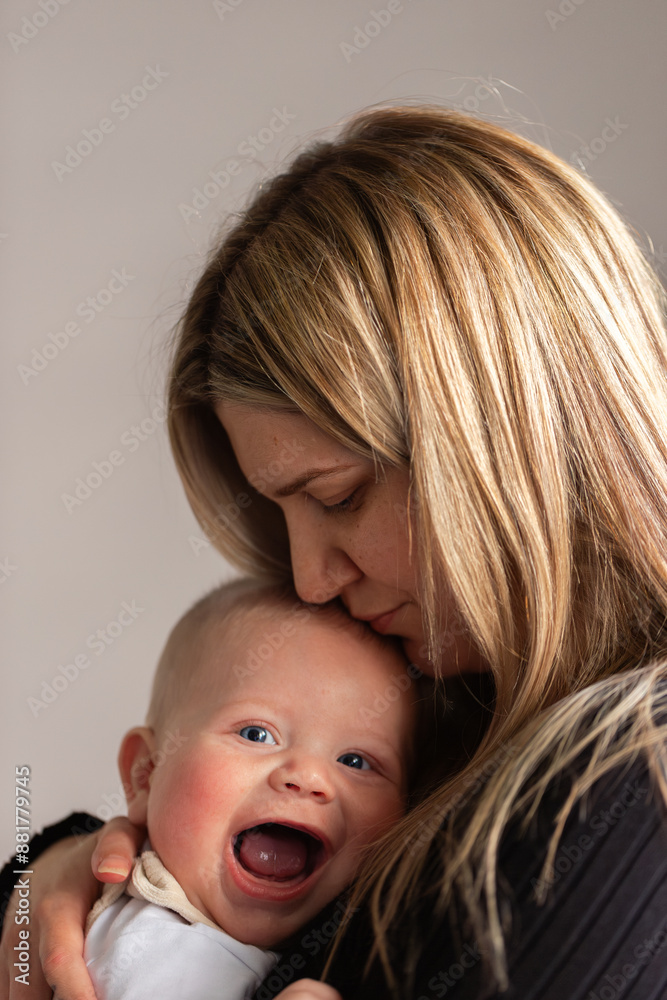 laughing baby boy held close in mothers arms laughing baby boy held close in mothers arms