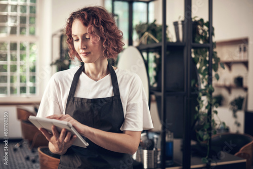 Beauty, salon and woman with tablet at work for job, planning and reading online booking info. Small business, person and stylist with tech in spa for client portfolio, research and hair care tips photo