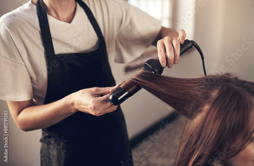 Hairdresser, woman and client with curling tool for heat treatment, maintenance and haircare of natural change. People, designer and tools for consultation session, blowout and style at luxury salon