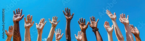 Multiple hands raised high in the air against a blue sky.