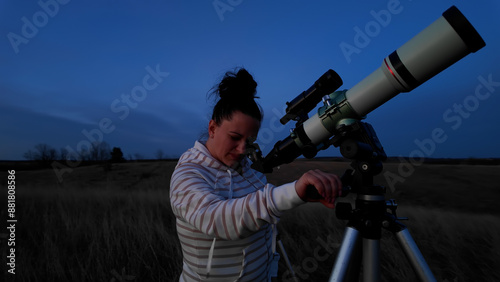 Amateur astronomer looking at the evening skies, observing planets, stars, Moon and other celestial objects with a telescope.