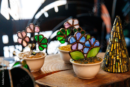 Stained Glass figures in shape of flowers pot in shop-front. colorful souvenirs