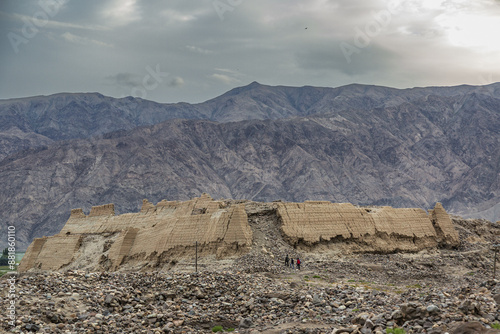 High angle and summer view of tourists walking on historic sites of fortress ruins against desert mountain at Pamir Plateau near Karakoram, Xinjiang Uyghur, China
 photo