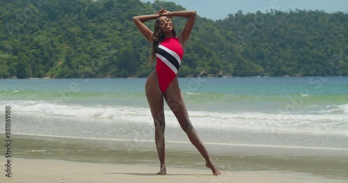 A young Trinidadian girl in a bikini is on the beach of the tropical island of Trinidad on a sunny day photo