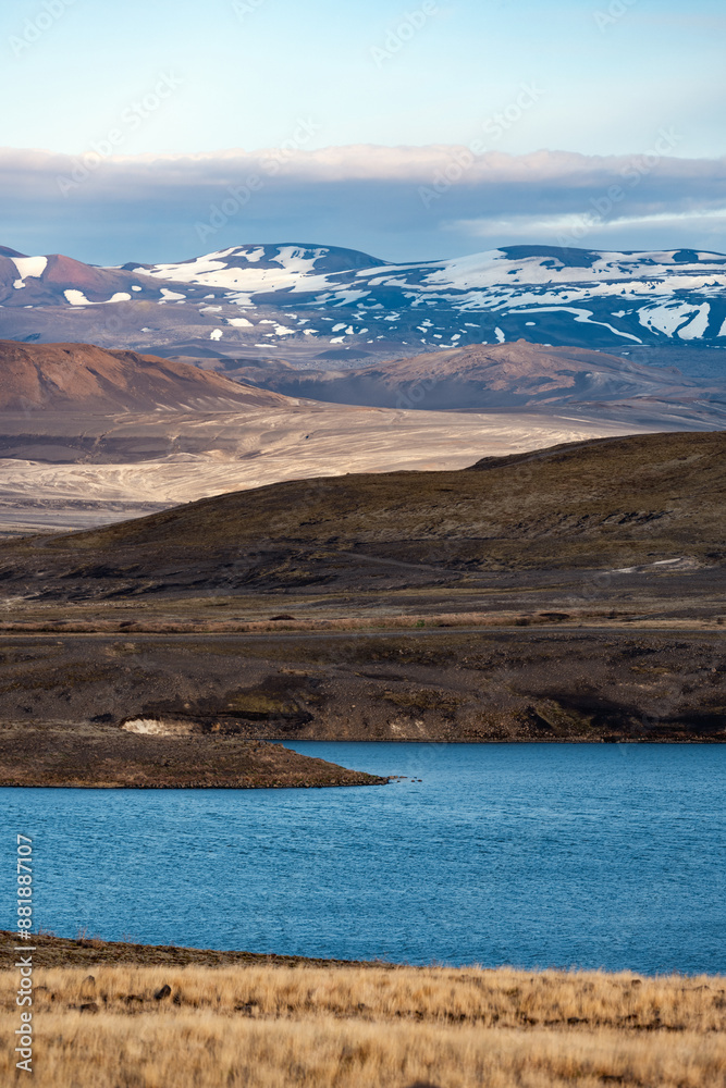 Stunning view of a dramatic landscape with a lake and snowy mountains in the distance.