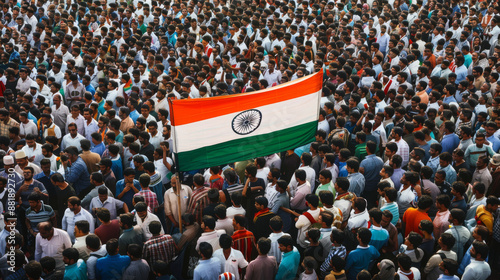 A sea of people gathered in a large crowd, holding high the Indian national flag amidst a vibrant atmosphere of unity and patriotism.