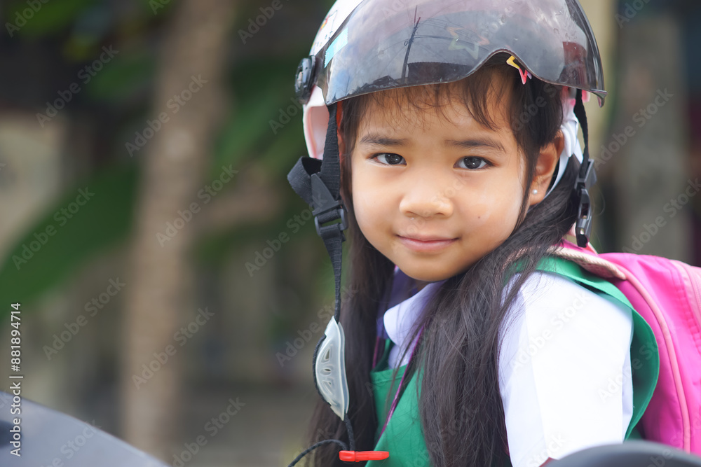 A headshot portrait of a Asian woman, a cute with adorable Wearing a helmet and carrying a pink bag while going to school.a child wearing a student form set smiling and looking to the camera. A headshot portrait of a Asian woman, a cute with adorable Wearing a helmet and carrying a pink bag while going to school.a child wearing a student form set smiling and looking to the camera.