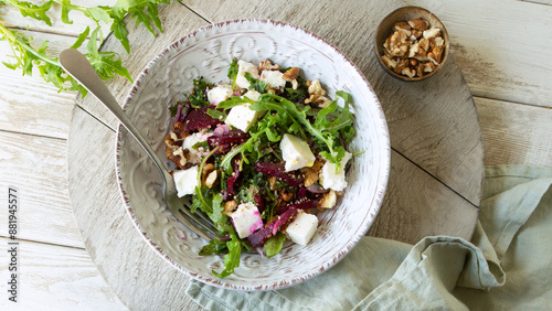 bowl of salad with baked beets and feta cheese on a light table, top view