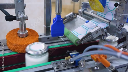 Close-up, pattern, automated conveyor, equipment at a dairy factory. Automatic line for gluing labels on cans of dairy products at a dairy factory. Milk bottling, packaging. Food industry, production