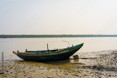 A traditional fishing boat is seen on a water creek on the coast of the Sundarbans delta. Concept of fishing and environment in Indian Sundarbans region