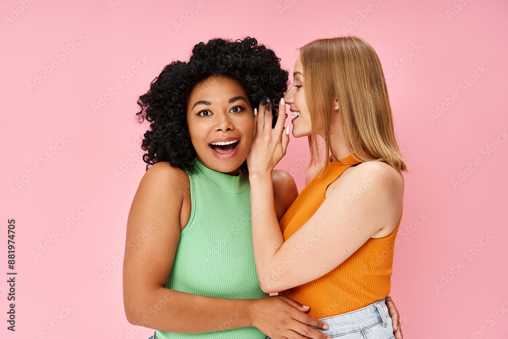 Two diverse women in casual attire pose gracefully against a soft pink backdrop. Two diverse women in casual attire pose gracefully against a soft pink backdrop.