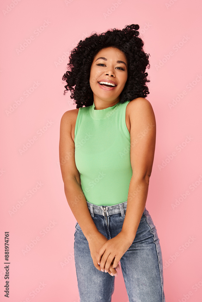 A woman in a green shirt and jeans strikes a pose for a picture. A woman in a green shirt and jeans strikes a pose for a picture.