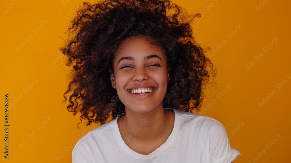 Headshot of a cheerful, laughing young woman with curly hair, wearing a t-shirt, smiling with white teeth, isolated on a bright yellow background. Headshot of a cheerful, laughing young woman with curly hair, wearing a t-shirt, smiling with white teeth, isolated on a bright yellow background.