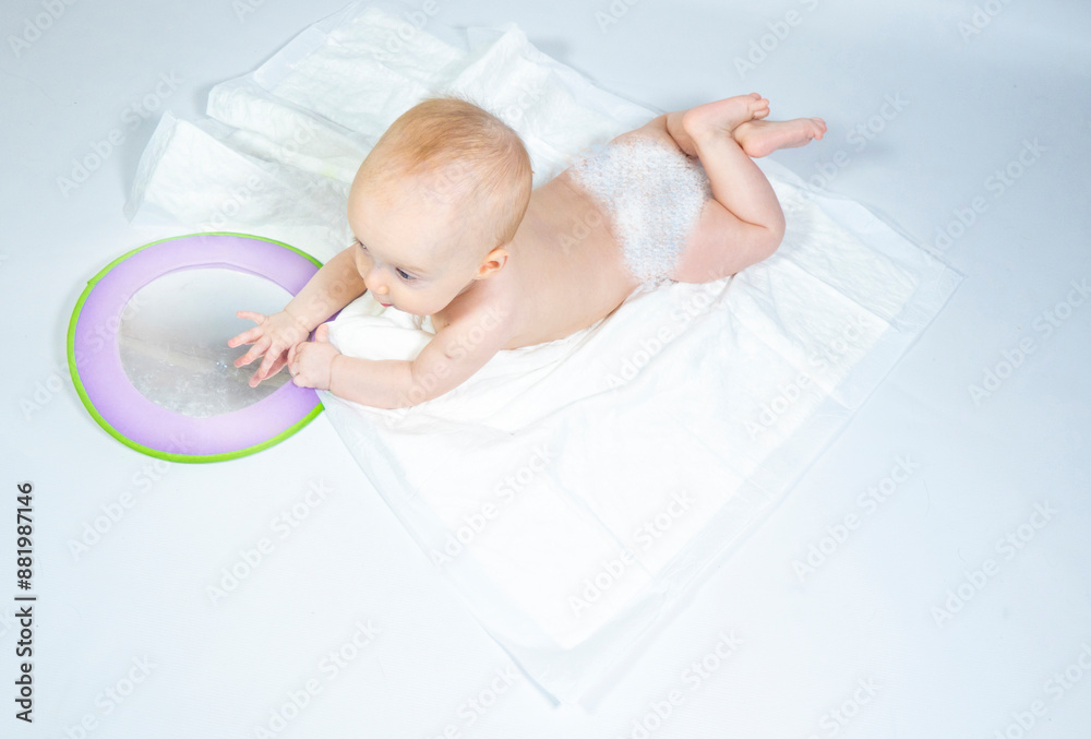 a baby with a mirror lies on a white background. banner with a copy space.